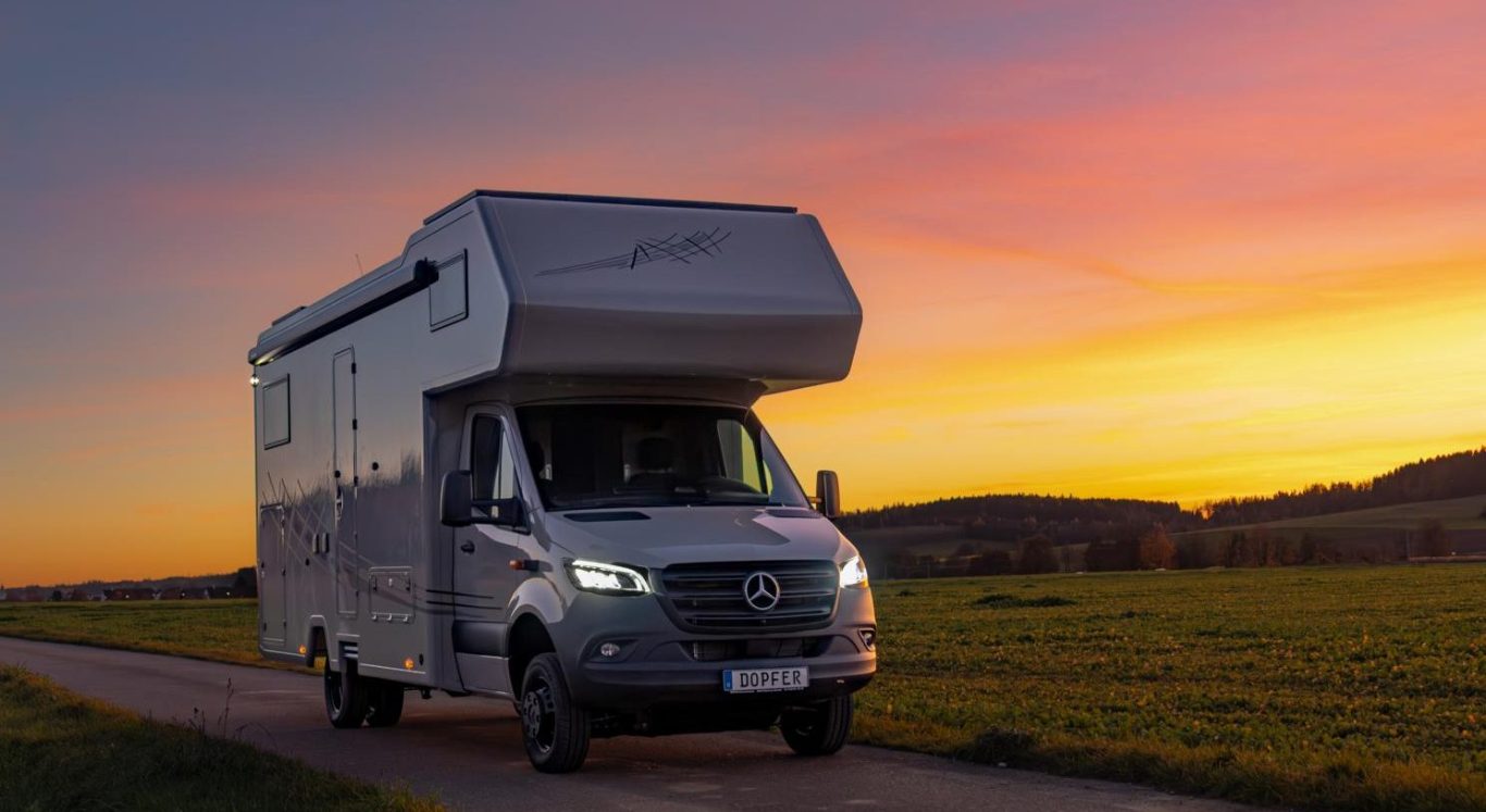 Impressionen Ein Wohnmobil fährt auf einer Landstraße bei Sonnenuntergang.
